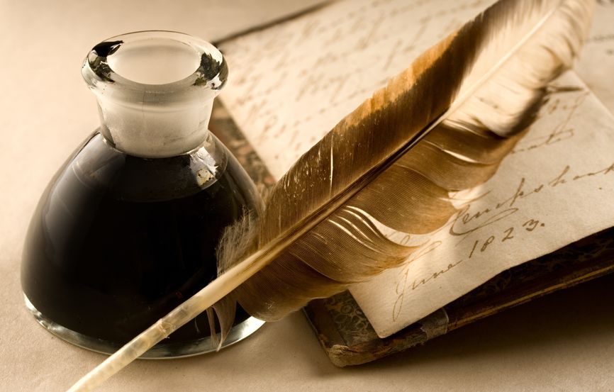 11293157 - an old book with a feather and the inkpot full of ink