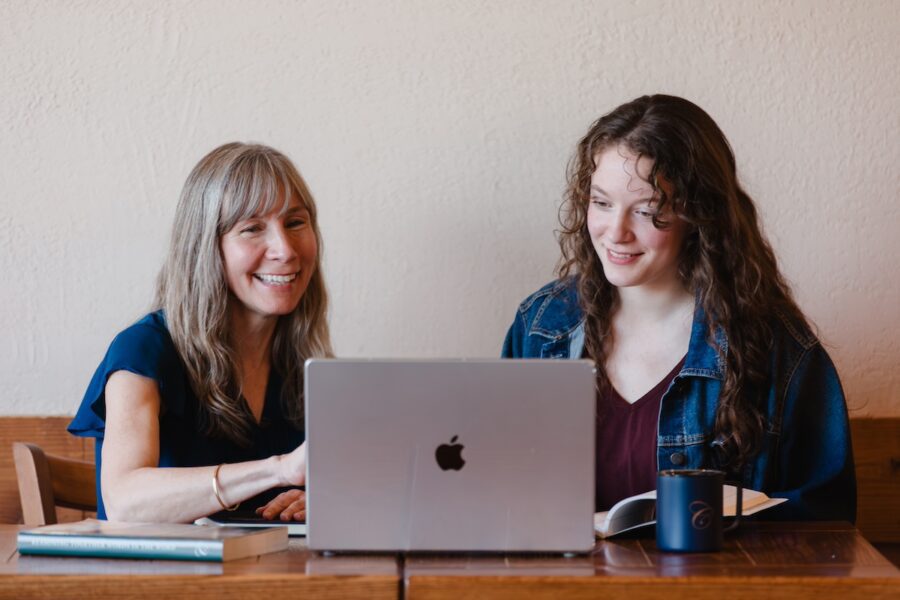 A mom and daughter looking at a laptop